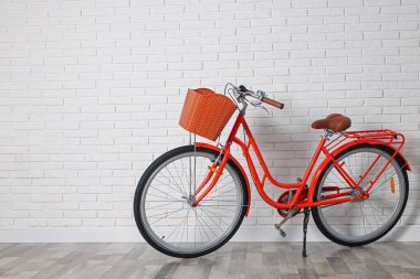 Beyaz tuğla duvarın yanında sepeti olan kırmızı bisiklet. Metin için boşluk