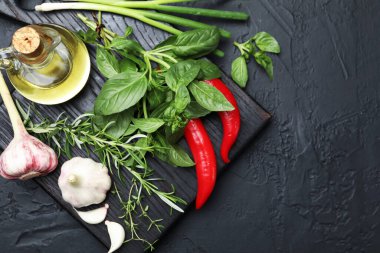 Farklı taze otlar ve baharatlar, siyah masa, üst manzara. Metin için boşluk