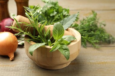 Tahta masadaki havanda farklı aromatik otlar, yakın plan.