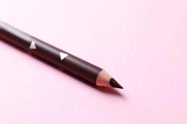 Pembe arka planda bir kaş kalemi, yakın plan. Metin için boşluk