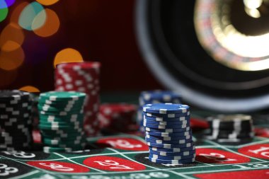 Rulet masasındaki kumarhane fişleri bulanık ışıklara karşı, yakın plan.