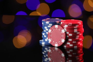 Ayna yüzeyindeki kumarhane çipleri bulanık ışıklara karşı, yakın plan. Metin için boşluk