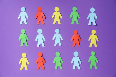 Mor zemin üzerinde kağıt insan figürleri, düz yatıyordu