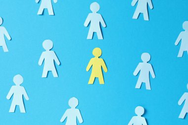 Kağıt insan figürleri ve açık mavi arka planda sarı olan, düz yatıyordu.