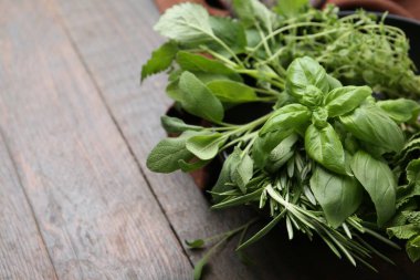 Tahta masadaki kasede farklı yeşil otlar, yakın plan. Metin için boşluk