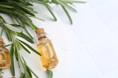 Beyaz fayanslı masa üzerinde gerekli yağ ve otlardan oluşan şişeler, düz. Metin için boşluk