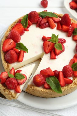 Üstünde çilek ve nane şekeri olan nefis bir cheesecake.