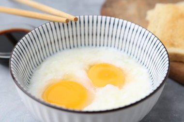 Kavanozda yarı haşlanmış yumurta, soya sosu, ekmek ve çubuklarla geleneksel Asya kahvaltısı, yakın plan.