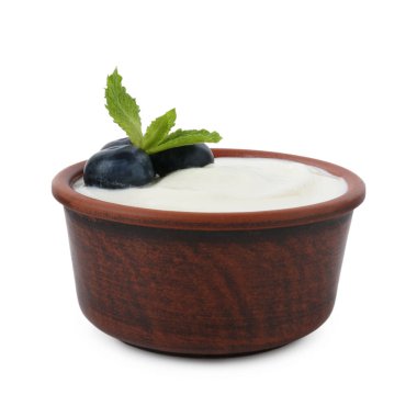 Lezzetli yoğurt yaban mersinli ve nane şekerli beyaz tencereye izole edilmiş.