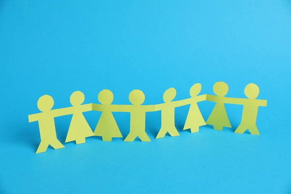Человеческие фигурки держатся за руки на светло-голубом фоне