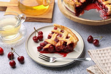 Lezzetli vişneli turta, böğürtlen ve çatal gri desenli masa, yakın plan.