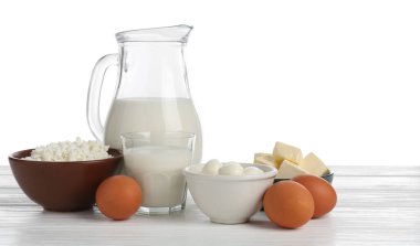 Farklı süt ürünleri ve yumurtalar beyaz arka plana karşı ahşap masa üzerinde