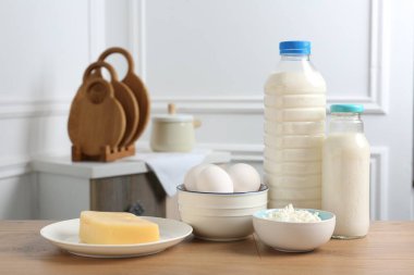 Farklı süt ürünleri ve yumurtalar ahşap masa içinde.
