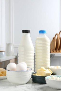 Beyaz mermer masa üzerinde farklı süt ürünleri ve yumurtalar.