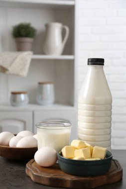 Mutfaktaki gri desenli masada farklı süt ürünleri ve yumurtalar.
