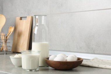 Mutfaktaki gri desenli masada farklı süt ürünleri ve yumurtalar.