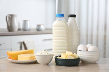 Mutfaktaki ahşap masada farklı süt ürünleri ve yumurtalar.