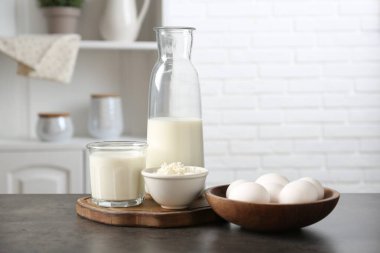 Mutfaktaki gri desenli masada farklı süt ürünleri ve yumurtalar.