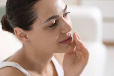 Dudak kremi sürmüş genç bir kadın.