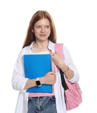 Sırt çantası ve beyaz arka planda defterleri olan tatlı bir genç kız.