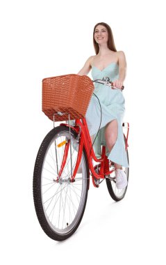 Gülen kadın beyaz arka planda sepeti olan bisiklet sürüyor, düşük açılı.