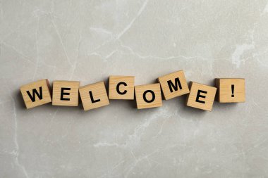 Kelime Hoş Geldiniz ve ünlem işareti Gri mermer arka planda tahta küplerden yapılmış, üst görünüm