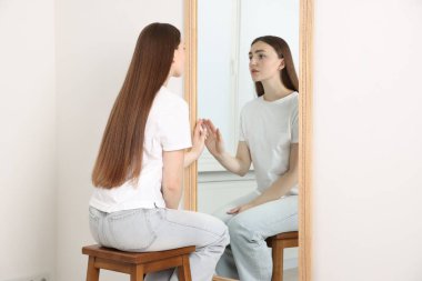 Güzel bir kadın aynada kendine bakıyor.