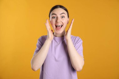 Turuncu arka planda şaşırmış kadın portresi