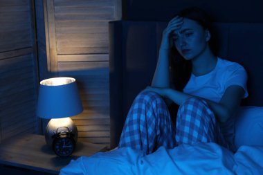 Evde yatağında uykusuzluk çeken hayal kırıklığına uğramış bir kadın.