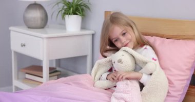 Evde oyuncak tavşancığı olan küçük bir kız.