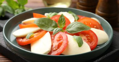 Masadaki lezzetli Caprese salatasına yağ dök, yakın plan.