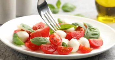 Masada çatalla lezzetli Caprese salatası yemek, yakın plan.