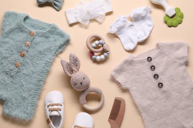 Bej arka planda bebek kıyafetleri ve aksesuarlar, düz yatış