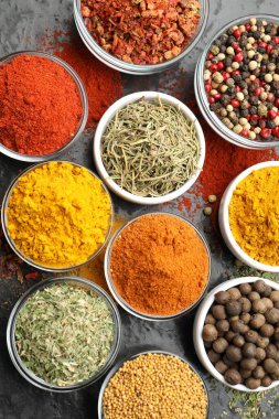 Tabaklardaki farklı aromatik baharatlar koyu masada, düz yerde.