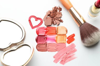 Farklı kozmetik ürünleri, beyaz arka planda ayna ve makyaj fırçası, düz konum