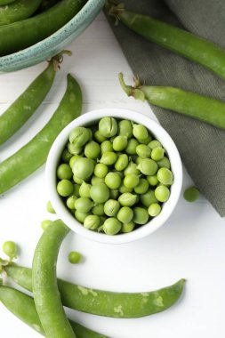 Taze taze bezelyeler beyaz ahşap masada, düz yatıyordu.