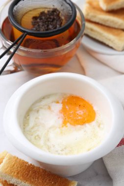 Yarı haşlanmış yumurta, çay ve kızarmış ekmek beyaz mermer masada, yakın plan. Geleneksel Asya kahvaltısı
