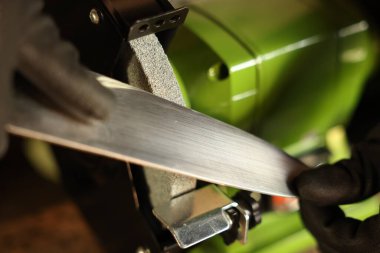 Bıçak keskinleştiren adam içeride, yakın plan.