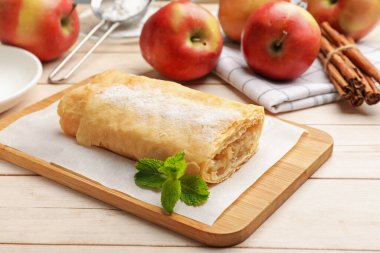 Lezzetli elmalı turta pudra şekeri, nane, meyve ve tarçınlı ahşap masa, yakın plan.