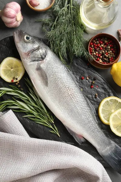Gri masadaki baharatlı taze çiğ deniz kabuğu, düz. Balık ve deniz ürünleri lezzetleri