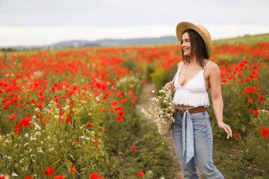Gülen kadın şapkalı, papatya çiçekli yaban çiçeği çayırında