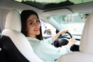 Araba kullanırken direksiyon tutan kadın.