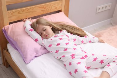 Evde yatakta uyuyan küçük kız