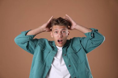 Kahverengi arka planda şaşırmış bir adamın portresi