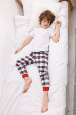 Evdeki yatakta uyuyan şirin küçük çocuk, üst manzara.