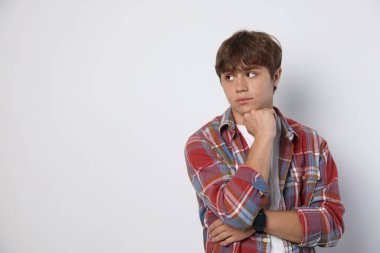 Açık gri arka planda sevimli bir genç çocuk. Metin için boşluk