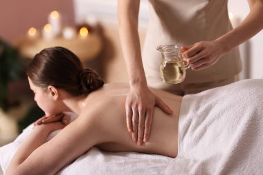 Spa salonunda kadın sırt masajı yaptırıyor.