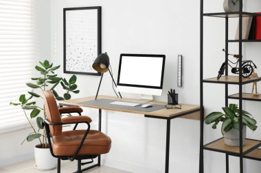 Ahşap masalı, lambalı ve bilgisayarlı şık bir iş yeri. Tasarım için model