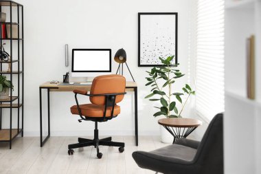 Ahşap masalı, lambalı ve bilgisayarlı şık bir iş yeri. Tasarım için model