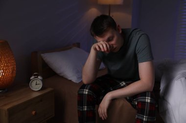 Yatakta uykusuzluk çeken sinirli bir adam.